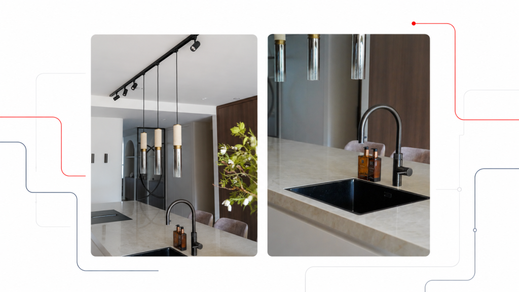 Moderne keuken met zwarte spoelbak, zwarte kraan en hangende cilindervormige verlichting boven het aanrecht.